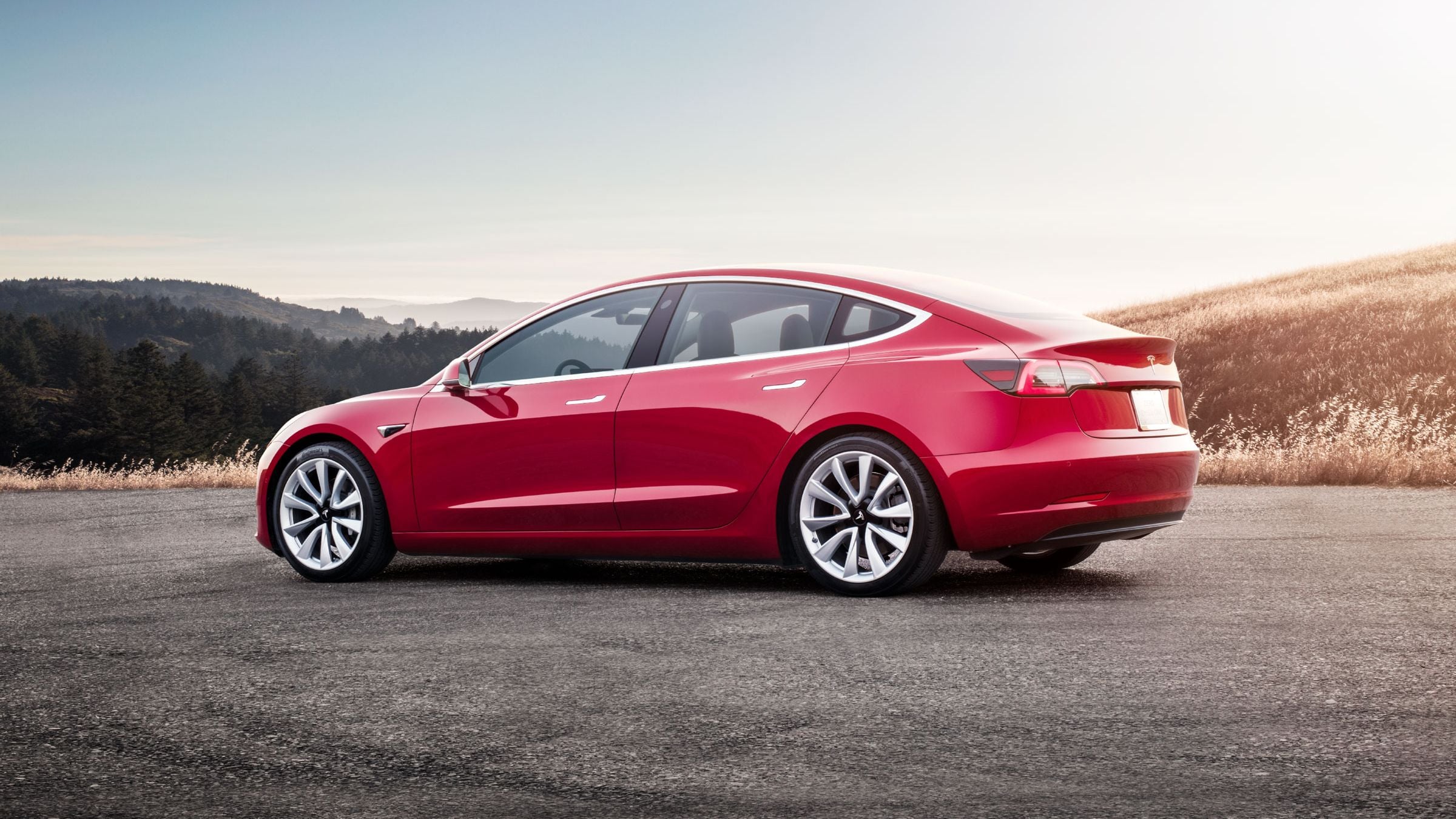 Красный Tesla Model 3 на горной дороге