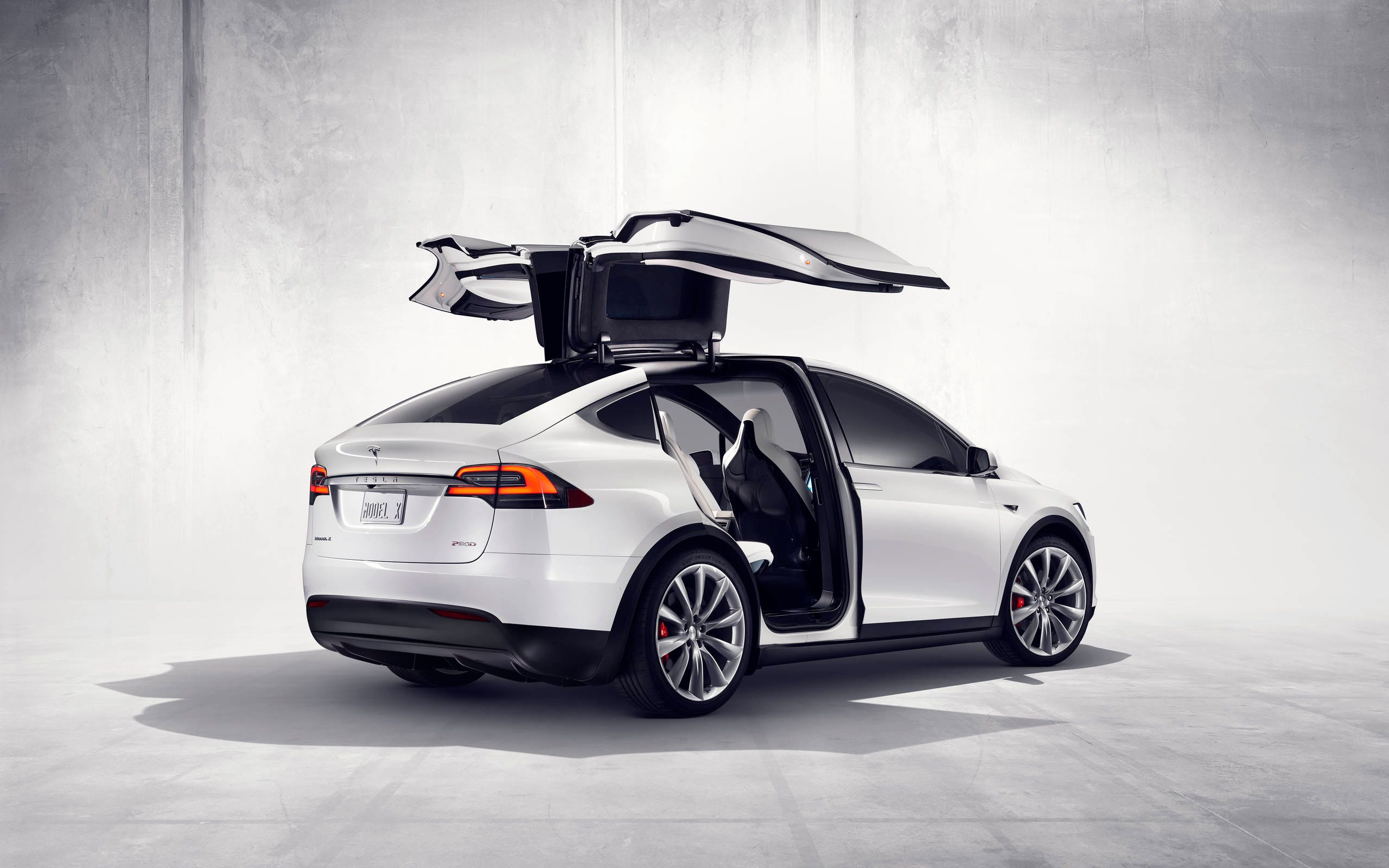Белый Tesla Model X с открытыми дверями «крыло сокола»